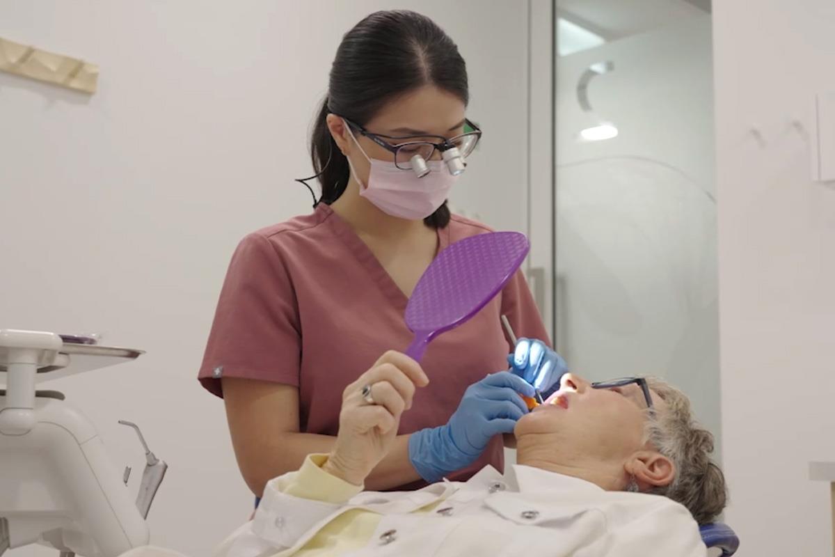 hygienist working on patient with mirror