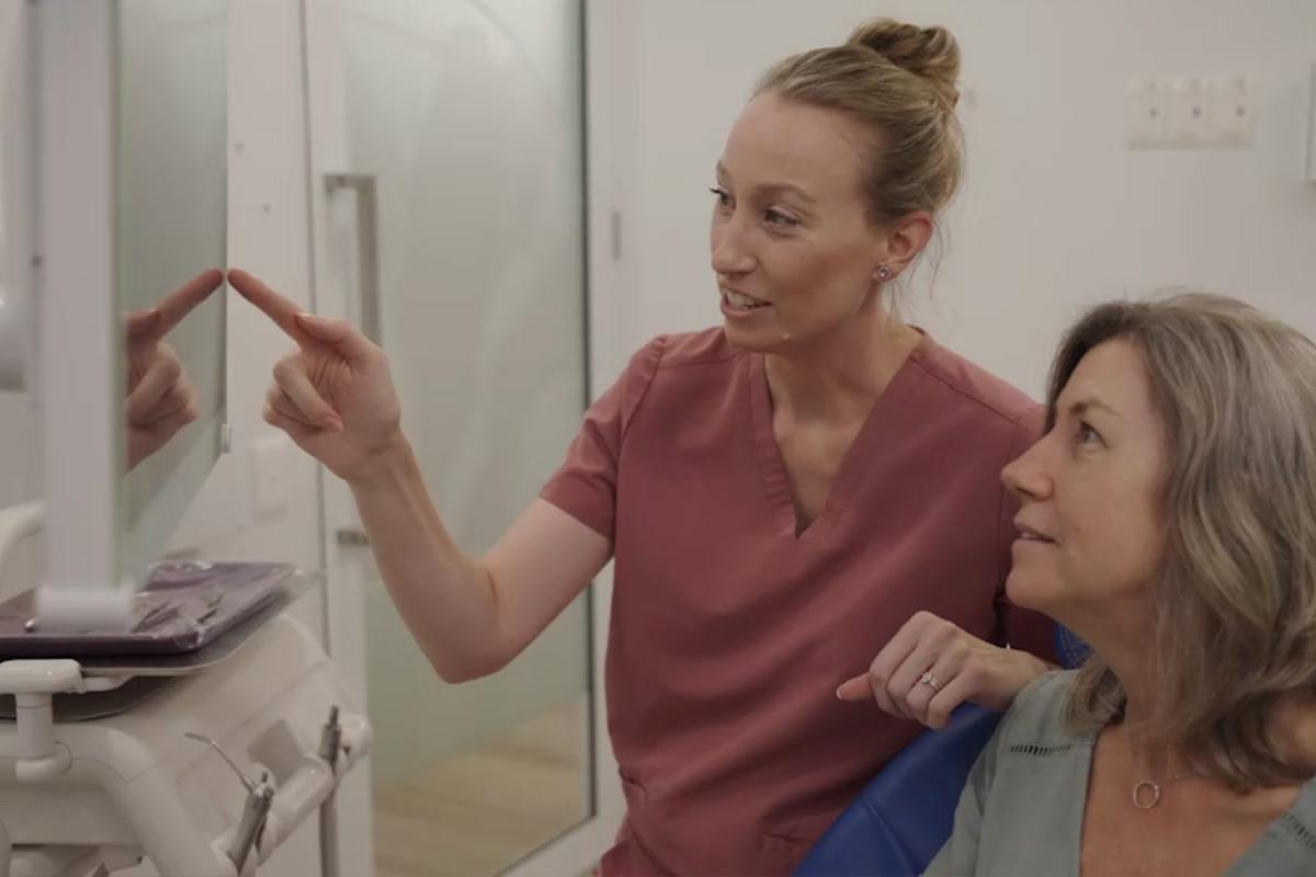periodontist pointing at scans